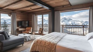 A room with a bed, a sofa, a TV, and a balcony with a mountain view.