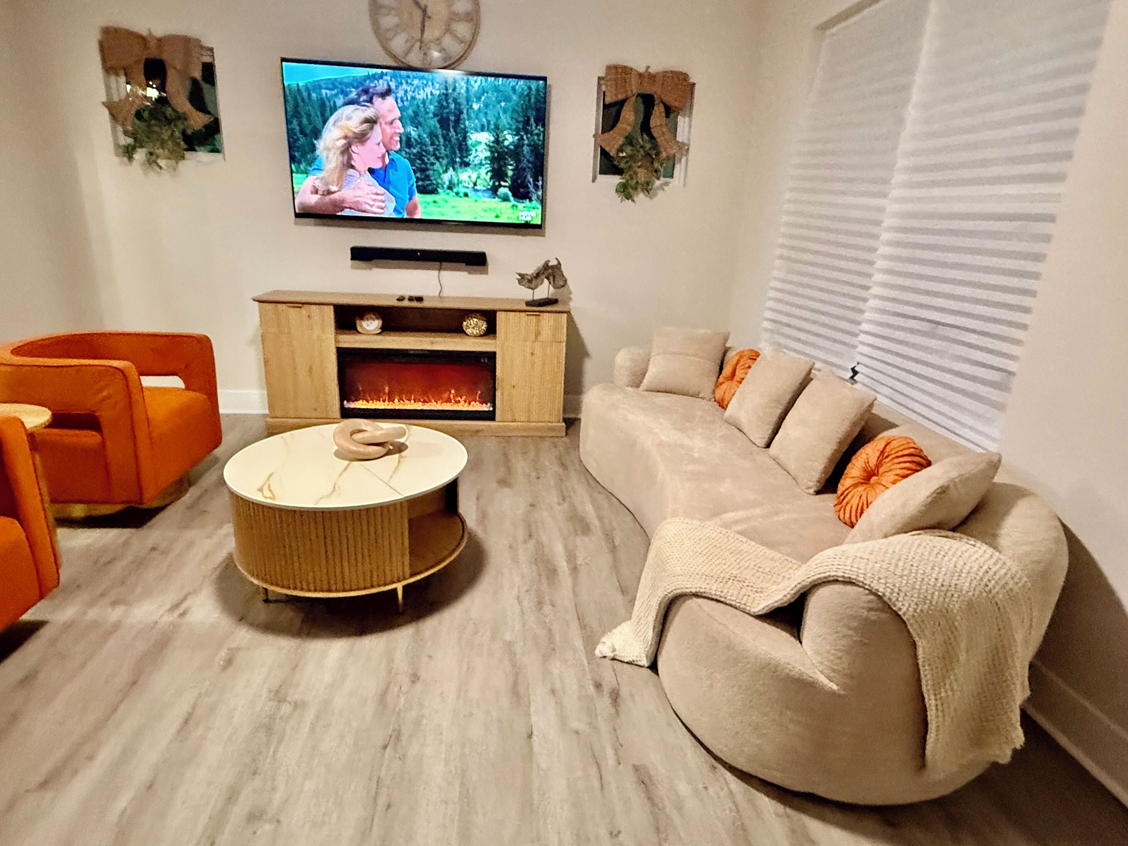 A living room with a television, a sofa, a coffee table, and a fireplace.