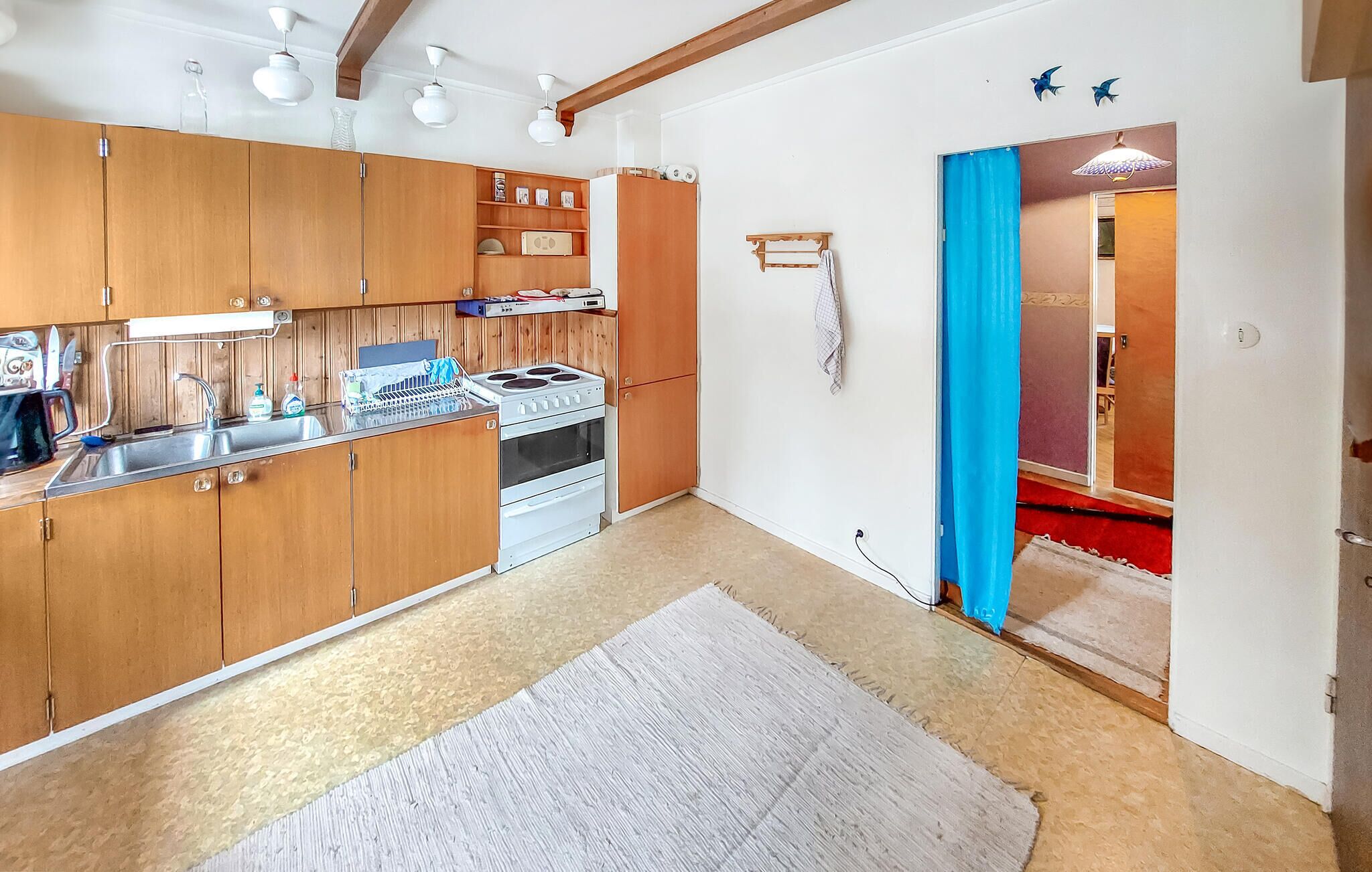 A kitchen with wooden cabinets, a stove, and a sink.