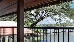 Un espacio al aire libre techado con vista a un río y un puente.