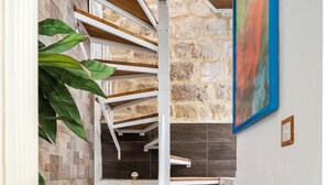 A staircase with wooden steps and a stone wall. - Chic Comfy 1BR Maisonette Valletta Area (Floriana)