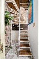 A staircase with wooden steps and a stone wall.
