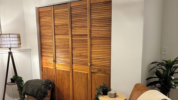 A room with a wooden wardrobe, a wicker chair, a small round table, and a potted plant. - Fantastic 1-bedroom townhome apartment in Spokane perfect for your getaway (Spokane)