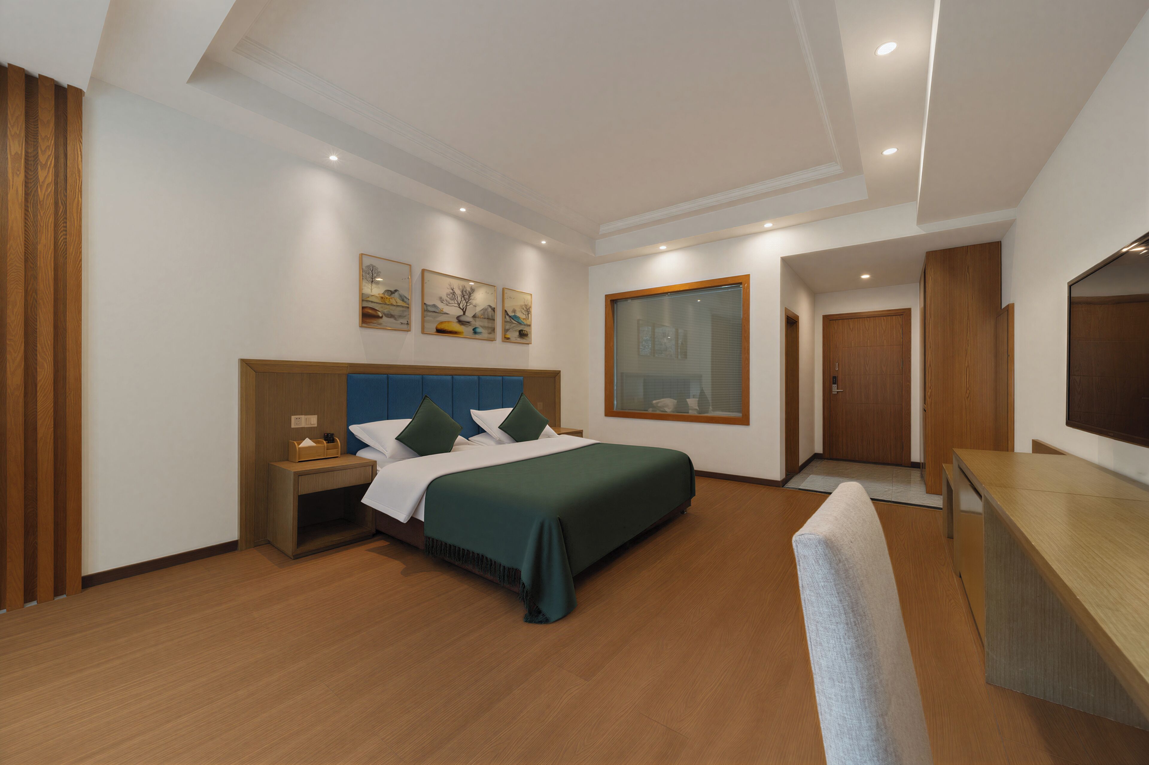 A modern hotel room with a large bed, bedside tables, a desk, and a large window.