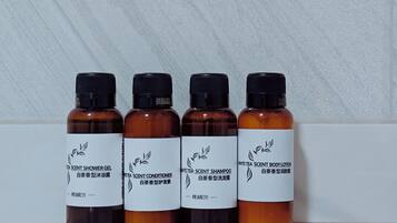 Quatre flacons de produits parfumés au thé blanc, placés sur une surface réfléchissante.