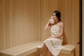 A person in a wooden room with a bench and a wooden wall. - Anook Hotel Jungangro Station (Daejeon)