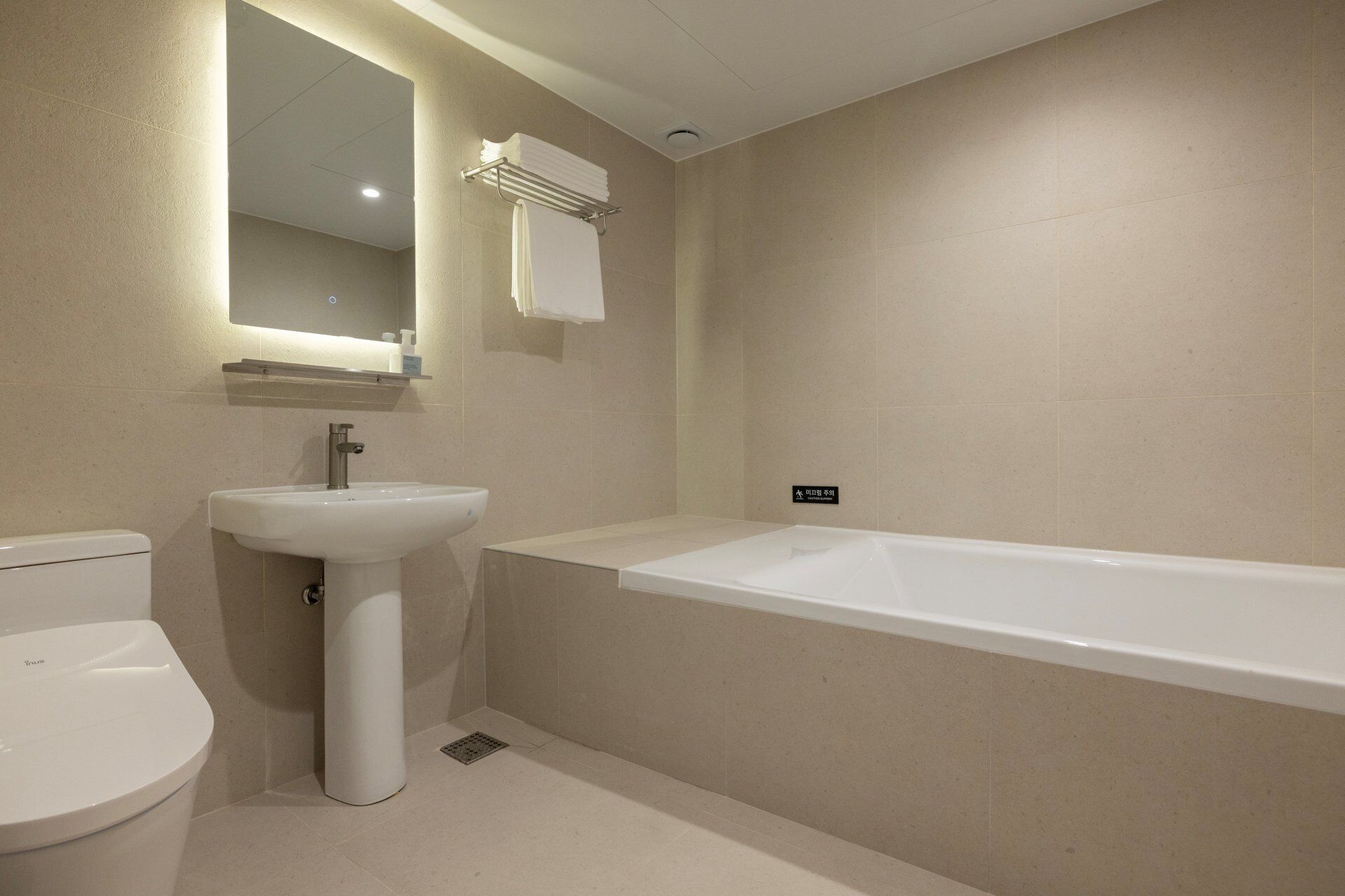 A bathroom with a toilet, sink, and bathtub.