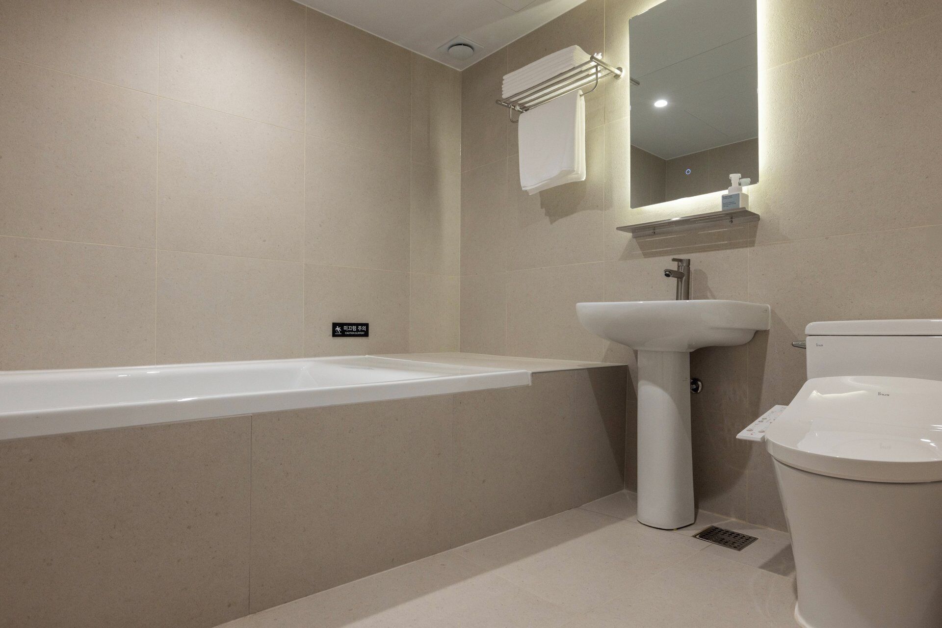 A modern bathroom with a bathtub, sink, and toilet.