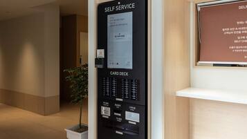 Un terminal automático de autoservicio con lector de tarjetas, dispensador de efectivo y ranura para identificación.