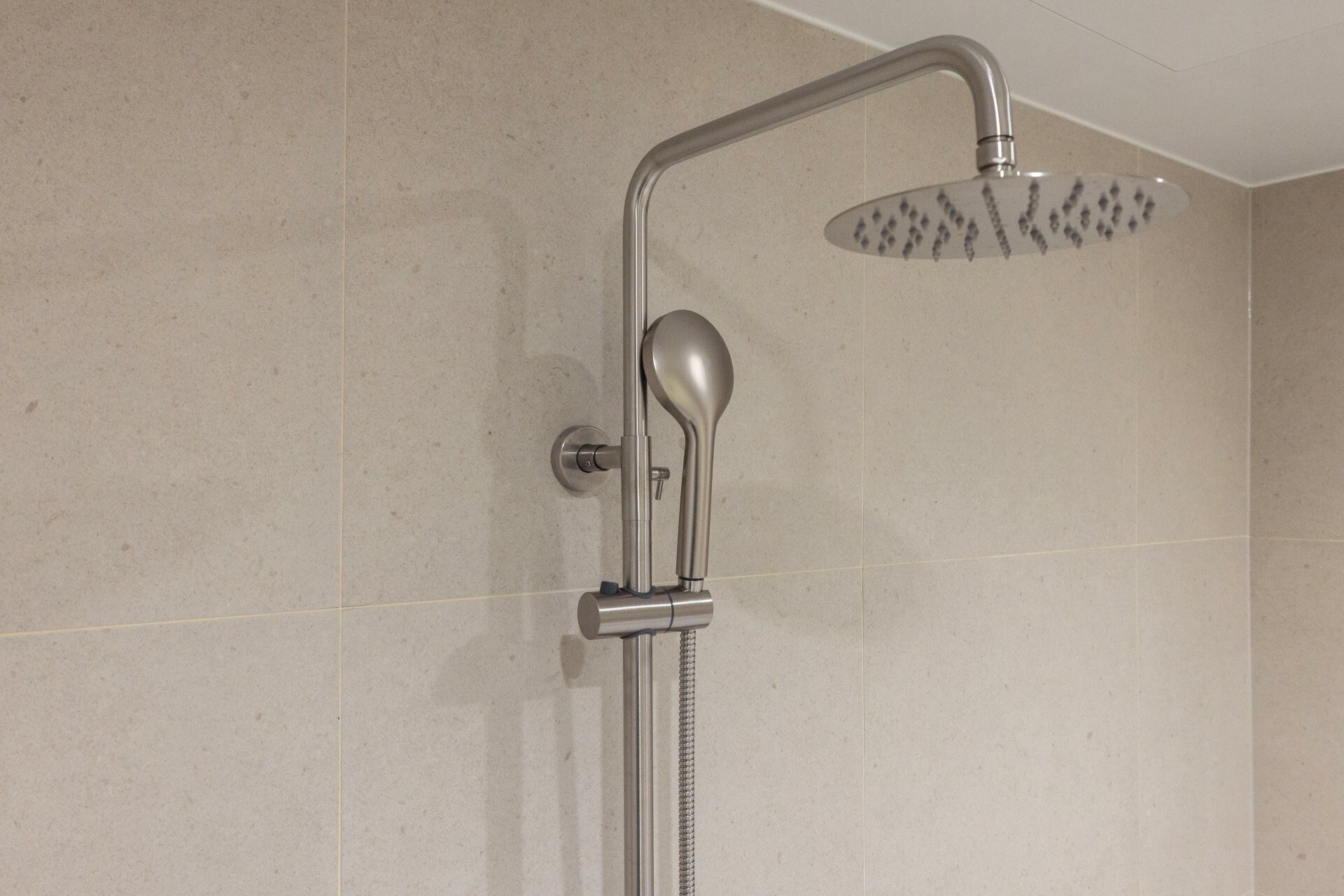 Eine Dusche mit Handbrause und Regendusche.