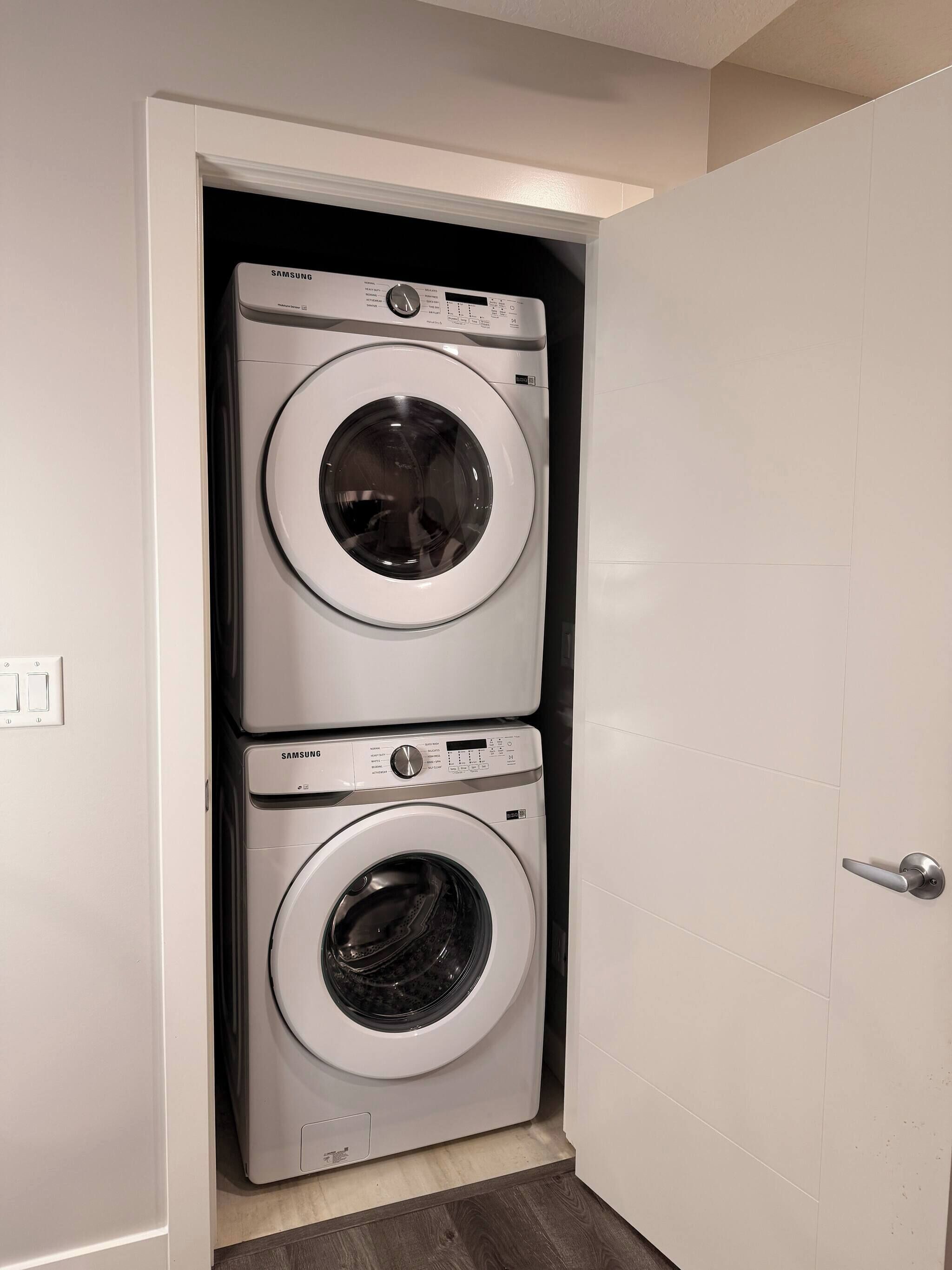 Un cuarto de lavandería con dos lavadoras apiladas.