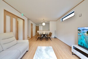 Un salon moderne avec un canapé, une table à manger et un téléviseur.