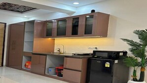Una cocina compacta con armarios empotrados, un refrigerador y un microondas.