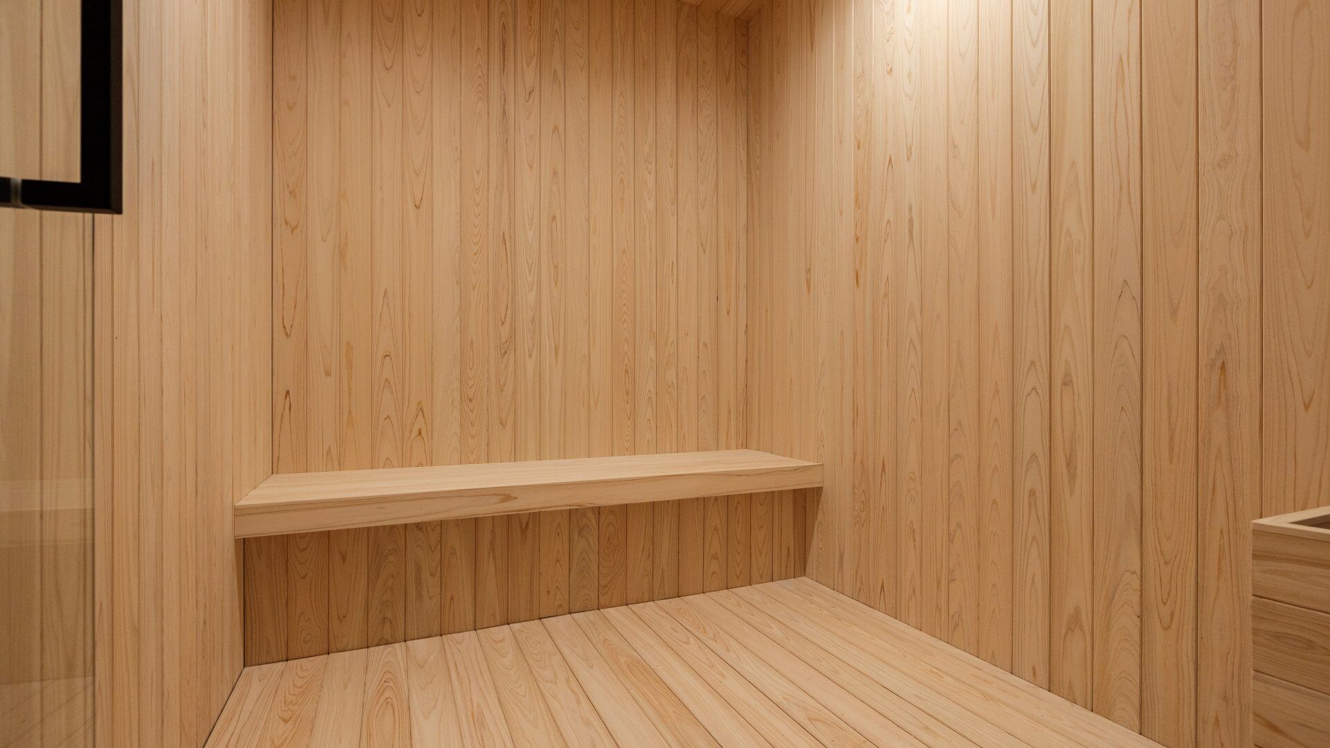 A wooden room with a built-in bench and a wooden floor.
