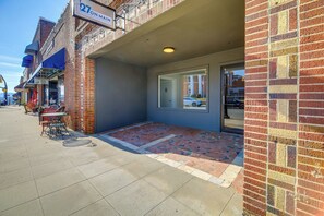 A brick building with a storefront, outdoor seating, and a clear sky.