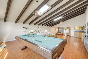 A pool table in a room with wooden beams and a skylight. - Bay Area Family Home w/ Indoor Pool + Game Room (South San Francisco)