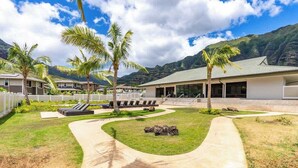 A resort with a paved walkway, palm trees, and a view of mountains. - @ Marbella Lane Hale Lai Serene Luxury 3BR Home (Waianae)