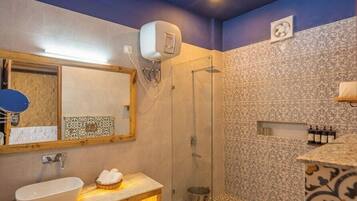 Un baño con lavamanos, espejo, ducha y paredes con diseño.