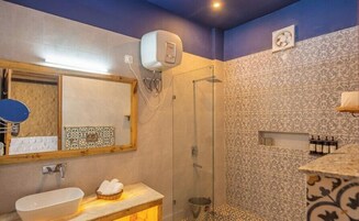 Un baño con lavamanos, espejo, ducha y paredes con diseño.
