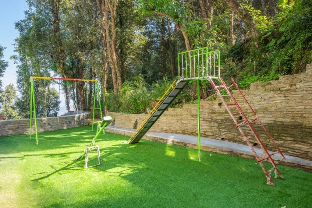 Une aire de jeux avec un toboggan, des balançoires et des structures d’escalade.