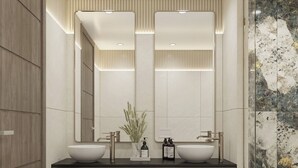 Un baño moderno con dos lavamanos, un espejo grande y una cabina de ducha con mampara de cristal.