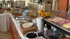 Un bufé con diversas opciones de comida, una máquina de café y una puerta con un diseño metálico decorativo.