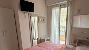 A bedroom with a bed, a desk, a wardrobe, a television, and a window with curtains. - Hotel de la Plage (Rimini)