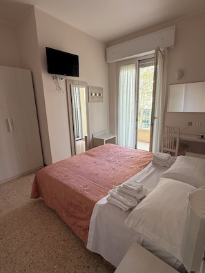 A bedroom with a bed, a desk, a wardrobe, a television, and a window with curtains. - Hotel de la Plage (Rimini)
