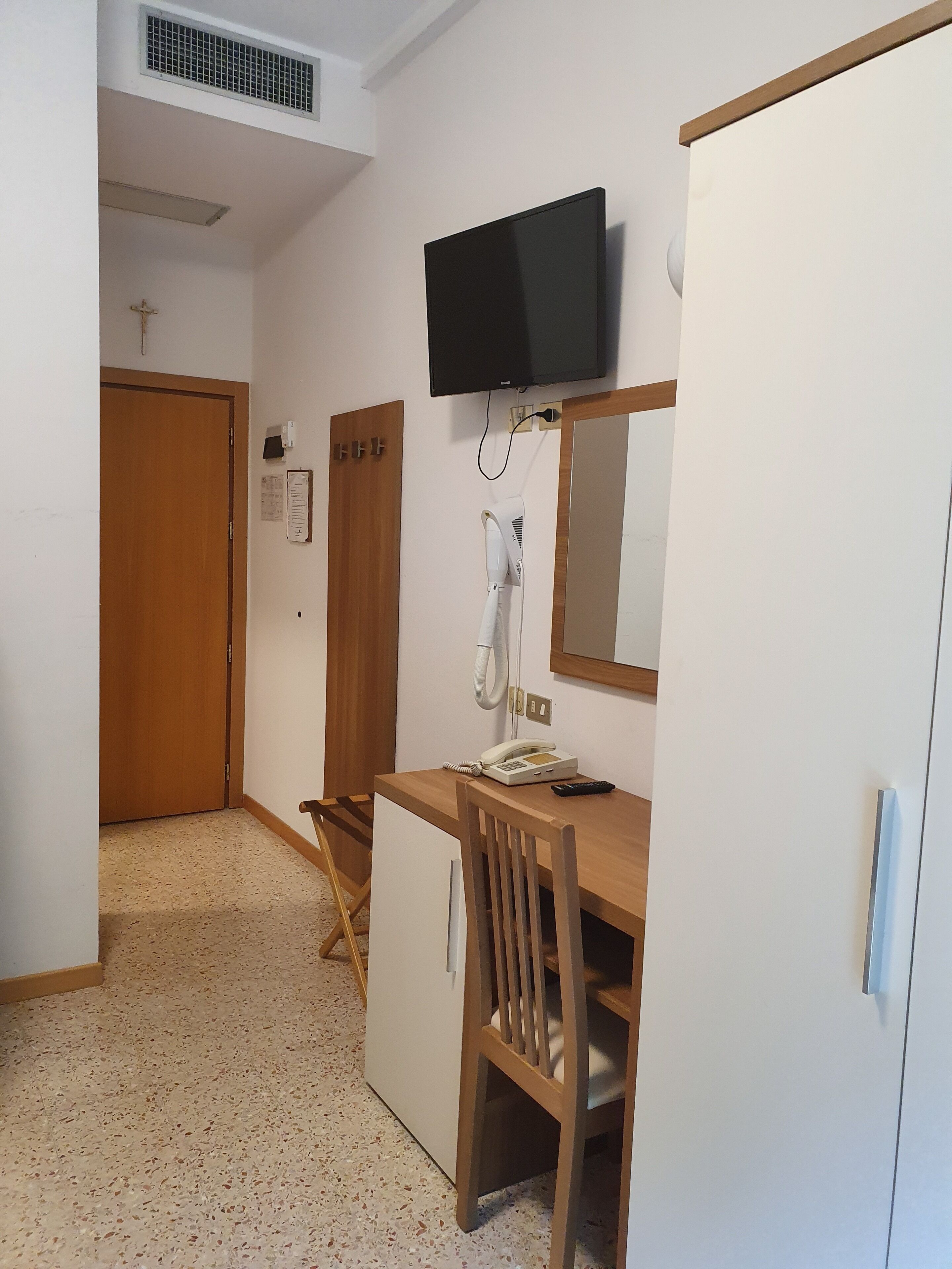 Une chambre à coucher comprenant un lit, un bureau, une chaise, une télévision et une armoire.
