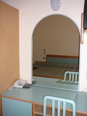A hotel room with a desk, chair, and a large mirror reflecting the bed and a nightstand. - Hotel de la Plage (Rimini)