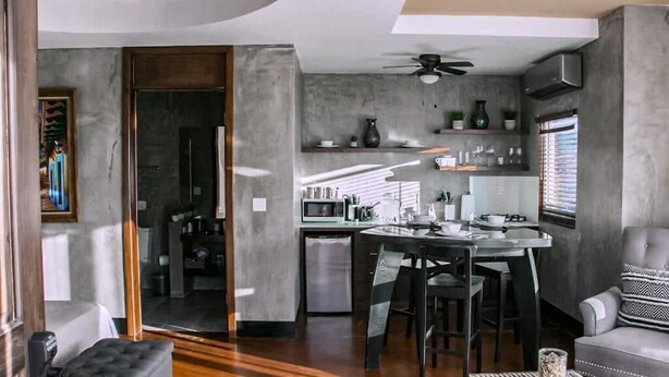 Uma cozinha moderna com área de jantar, sofá e mesa de centro.
