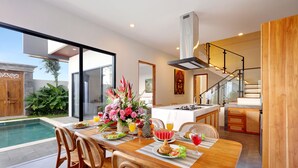 Una cocina moderna con comedor, piscina y escalera.