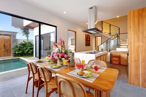 Una cocina moderna con comedor, piscina y escalera.