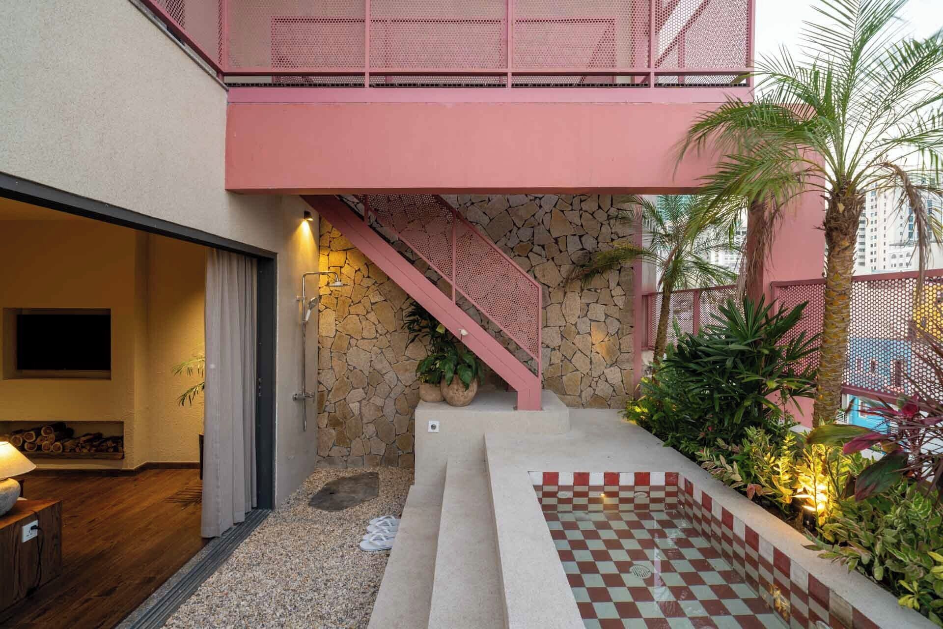 A modern interior with a staircase, stone wall, and indoor plants.
