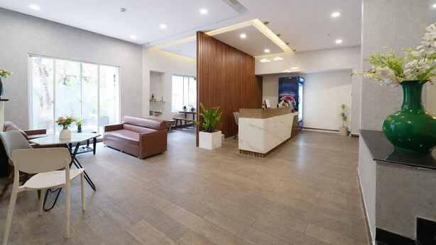 A modern hotel lobby with a reception desk, seating area, and large windows. - Palette Amura Hotel - Near Gigamall (Ho Chi Minh City)