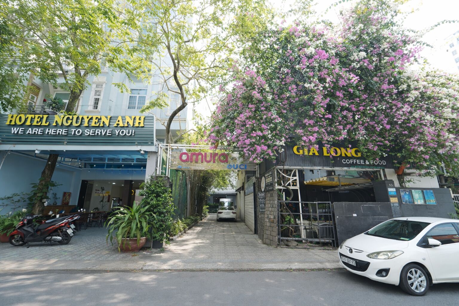 A street view with a hotel named 'HOTEL NGUYEN ANH' and a coffee shop named 'GIA LONG COFFEE & FOOD'.