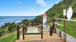 A wooden pathway leading to a beach with a sign indicating it's a national park. - Burleigh Coastal Escape 4BR Home (Burleigh Heads)