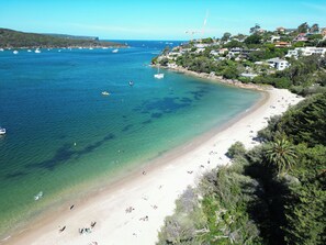 Eine Küstenlandschaft mit Strand, Booten und Häusern.