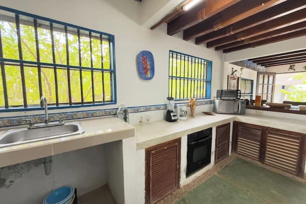 A kitchen with a sink, stove, and microwave.
