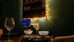 Un área de comedor con un reloj digital, copas de vino y un tablero de menú.