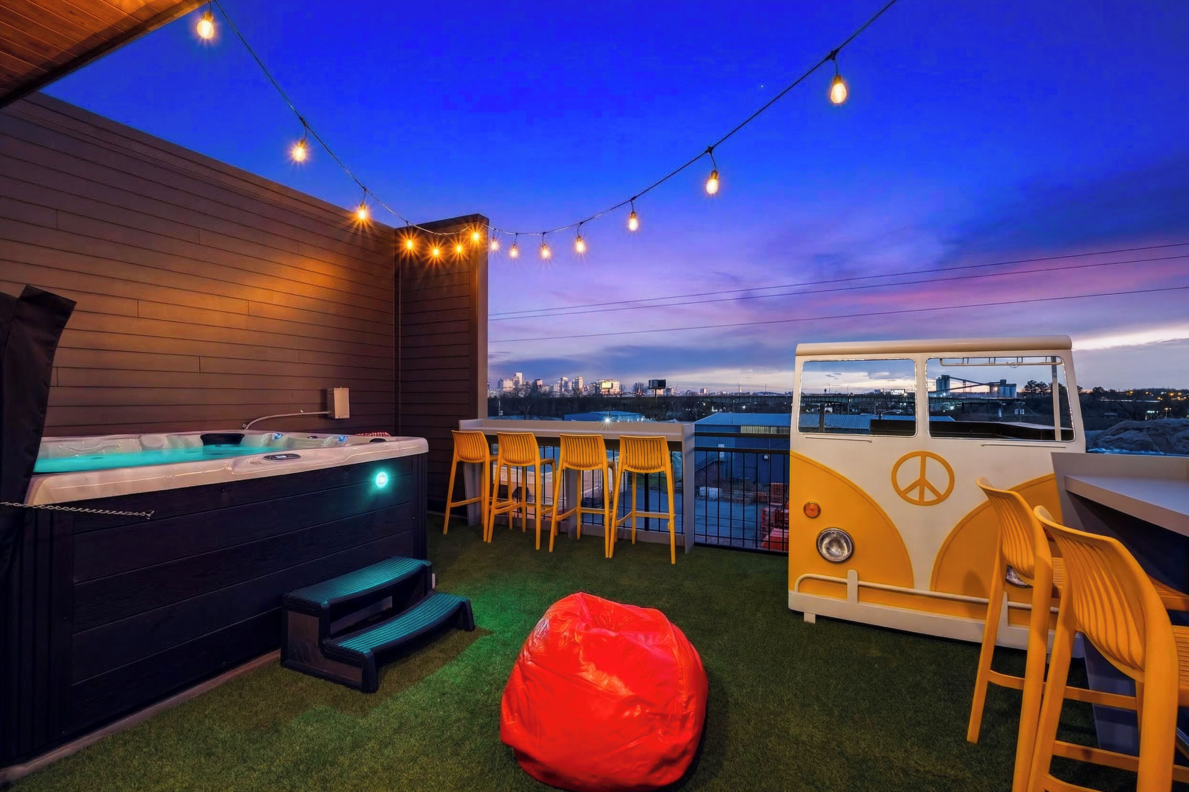 Um bar no terraço com banheira de hidromassagem, área de estar e vista para o horizonte da cidade.