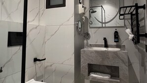 Moderni kylpyhuone, jossa on wc, pesuallas ja suihku.