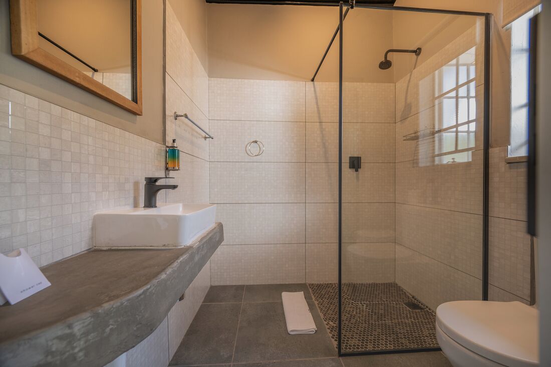 Een moderne badkamer met een douche, een wastafel en een toilet.