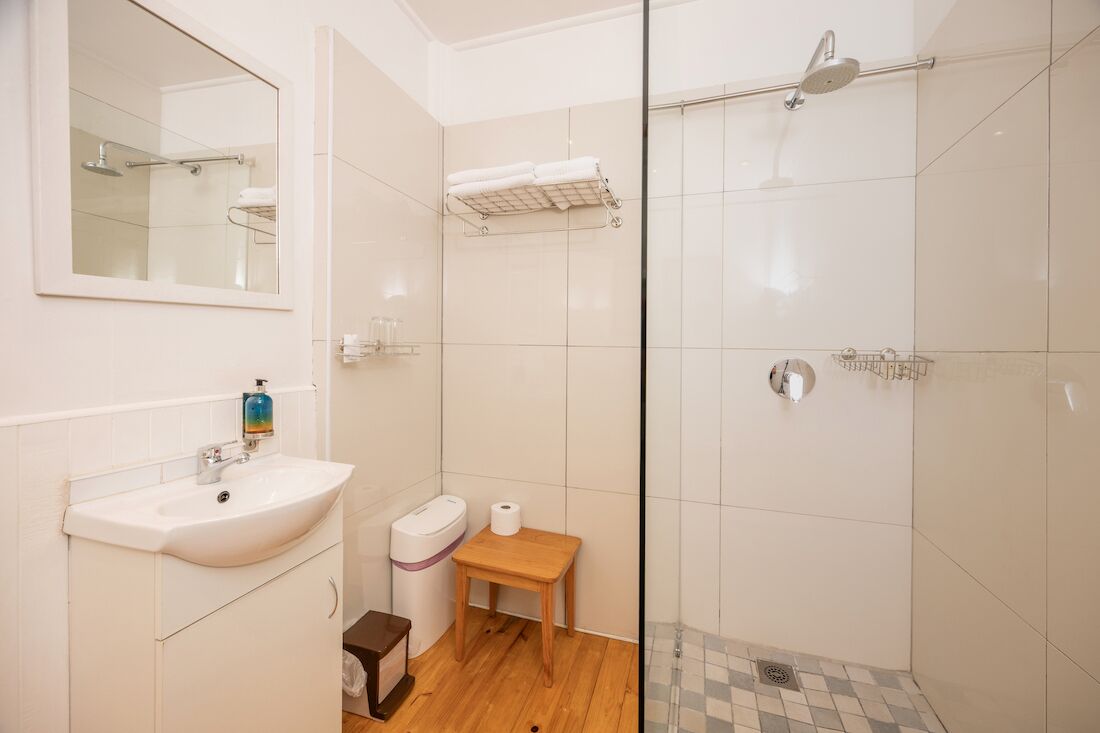Un baño con lavamanos, inodoro y ducha con cerramiento de vidrio.