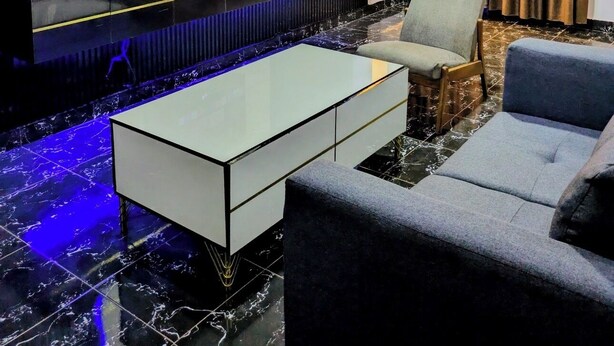 Una sala de estar moderna con un televisor de pantalla plana, un sofá, una mesa de centro y una pared con estampado.