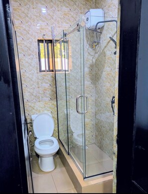 Een douche, handdoeken, zeep, toiletpapier
