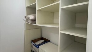 A white storage unit with multiple shelves, a small box on the bottom shelf, and a pillow on the top shelf. - Private Farm - Hot Pool, Jacuzzi & Games (Sopetrán)