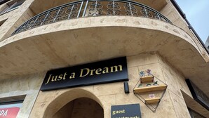 Un edificio con un cartel que dice 'Just a Dream' y otro cartel que indica apartamentos para huéspedes en la calle V. Levski.