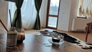 Una habitación con una mesa de madera, un globo terráqueo, una botella y una taza de café.