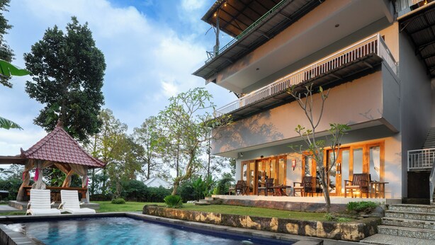 A modern hotel with a swimming pool, outdoor seating, and a covered area. - DWM Mandhasativa Homestay By Reccoma (Sawan)